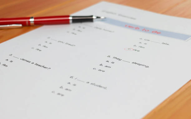 English grammar test sheet on wooden table in classroom